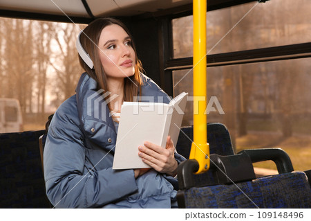 Woman listening to audiobook in trolley bus Woman listening to audiobook in trolley bus 109148496