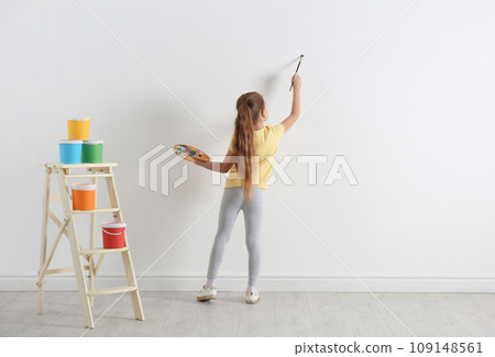 Little child painting on blank white wall indoors 109148561