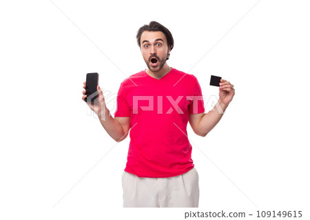 young slender brunette advertiser man dressed in a red T-shirt with surprise shows a plastic credit young slender brunette advertiser man dressed in a red T-shirt with surprise shows a plastic credit 109149615