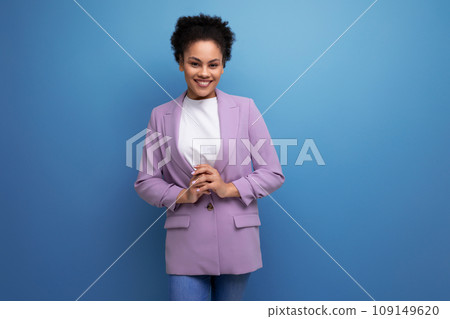 young successful latin woman with afro hair dressed in a lilac jacket on a studio background 109149620