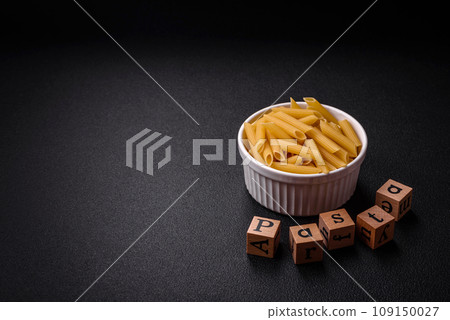 Raw penne pasta from whole grain wheat varieties with salt and spices Raw penne pasta from whole grain wheat varieties with salt and spices 109150027