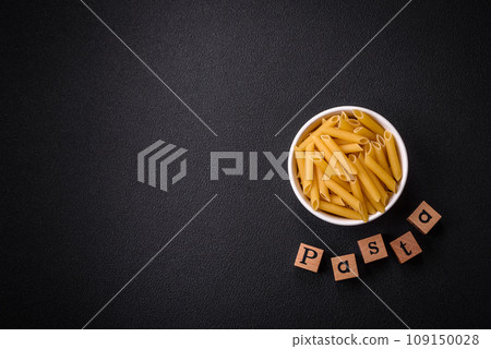 Raw penne pasta from whole grain wheat varieties with salt and spices Raw penne pasta from whole grain wheat varieties with salt and spices 109150028