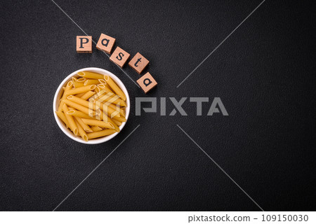 Raw penne pasta from whole grain wheat varieties with salt and spices Raw penne pasta from whole grain wheat varieties with salt and spices 109150030