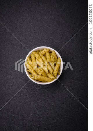 Delicious fresh pasta penne with green pesto sauce with basil, salt and spices 109150058