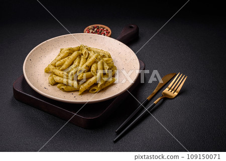 Delicious fresh pasta penne with green pesto sauce with basil, salt and spices 109150071