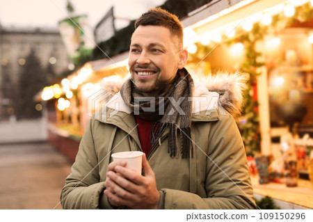Happy man with mulled wine at winter fair Happy man with mulled wine at winter fair 109150296