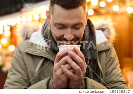 Happy man with mulled wine at winter fair Happy man with mulled wine at winter fair 109150297
