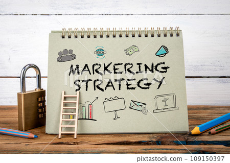 Marketing Strategy. Green notepad on wooden texture table and white background 109150397