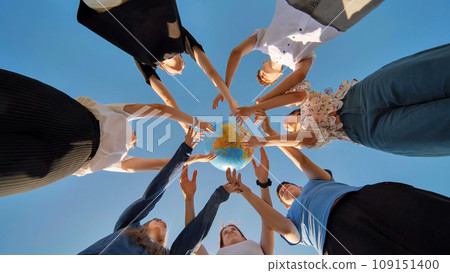 Friends hold and toss a geographic globe in their hands. The concept of keeping the world safe. Friends hold and toss a geographic globe in their hands. The concept of keeping the world safe. 109151400