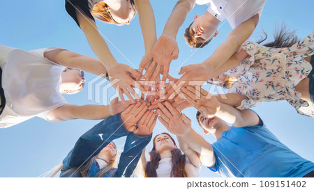 Friends putting their hands together in a sign of unity and teamwork. Just the hands. 109151402