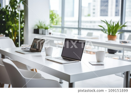 Fragment of modern minimalist office or coworking space. White desk with laptops, comfortable chairs, indoor plants. Panoramic windows overlooking the city in the background. Fragment of modern minimalist office or coworking space. White desk with laptops, comfortable chairs, indoor plants. Panoramic windows overlooking the city in the background. 109151899