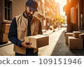 Close-up portrait of male delivery courier with cardboard box in a city street. Smiling positive Caucasian man delivering parcel to a client. Logistic and delivery concept. 109151946