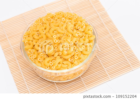 Uncooked Chifferi Rigati Pasta in Glass Jar on Bamboo Mat Uncooked Chifferi Rigati Pasta in Glass Jar on Bamboo Mat 109152204