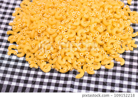 Scattered Uncooked Chifferi Rigati Pasta on Black Checkered Towel Scattered Uncooked Chifferi Rigati Pasta on Black Checkered Towel 109152218