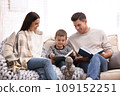 Happy family with little son reading books at home. Winter vacation 109152251