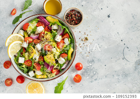 Delicious and healthy green salad of different leaves and vegetables with seeds and olive oil. 109152393