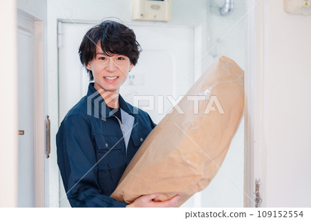 A man delivering a package to an old apartment building 109152554