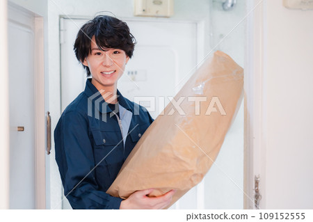 A man delivering a package to an old apartment building 109152555