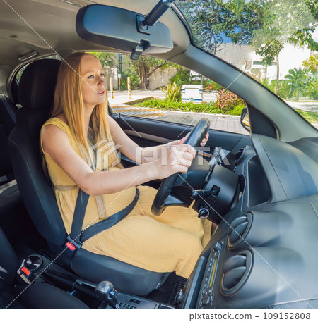 Pregnant empowerment on wheels a woman confidently drives, embracing motherhood while navigating the road with grace 109152808