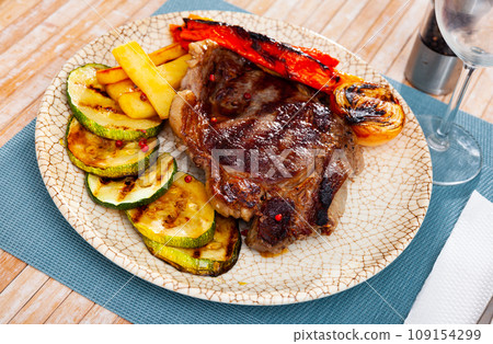 Delicious grilled beef steak with potatoes and vegetables Delicious grilled beef steak with potatoes and vegetables 109154299