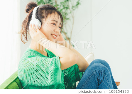 Young woman listening to music in the room Young woman listening to music in the room 109154553