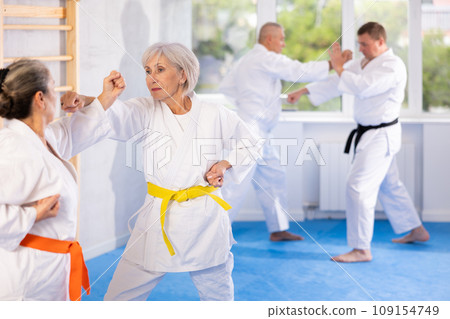 Senior karate practitioner engage in fierce fight oriental single combat Senior karate practitioner engage in fierce fight oriental single combat 109154749