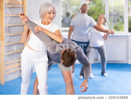 Old woman twisting her opponent's arm during self-defense classes Old woman twisting her opponent's arm during self-defense classes 109154809