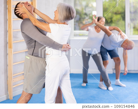Old woman practicing self-defense techniques in pairs Old woman practicing self-defense techniques in pairs 109154846