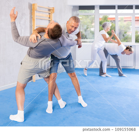 Old man practicing self-defense techniques in pairs 109155068