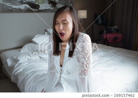 The woman woke up and yawned in the early morning. 109157462