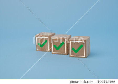 Wood cube with a check mark on background. Checklist concept list, vote, questionnaire, survey select the check list. Wood cube with a check mark on background. Checklist concept list, vote, questionnaire, survey select the check list. 109158366