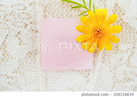Mockup of a pretty pink message frame decorated with yellow daisy flowers on a beige lace background 109158654