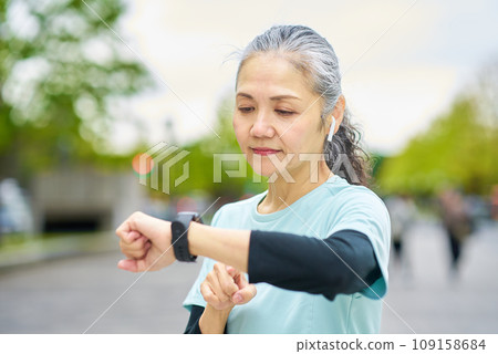 Senior woman operating a smartwatch 109158684