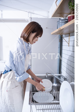 A woman doing housework in the kitchen A woman doing housework in the kitchen 109159900
