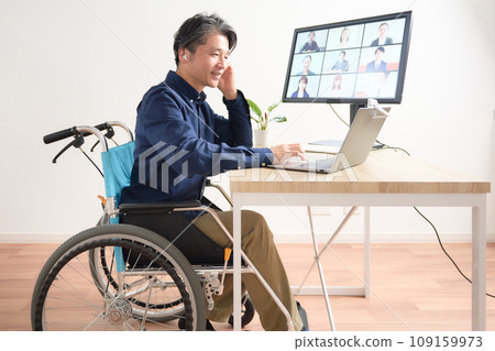 A man in a wheelchair having a video call A man in a wheelchair having a video call 109159973