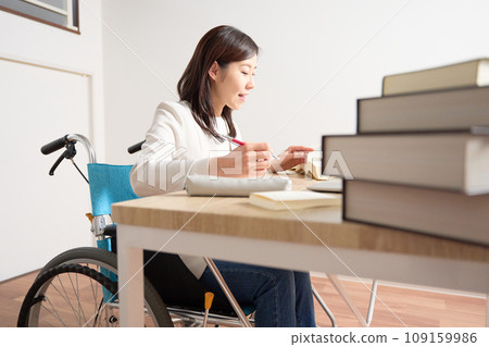 坐在輪椅上伏案學習的女人 109159986