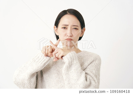 中年婦女用手指做十字標記手勢，白色背景 109160418