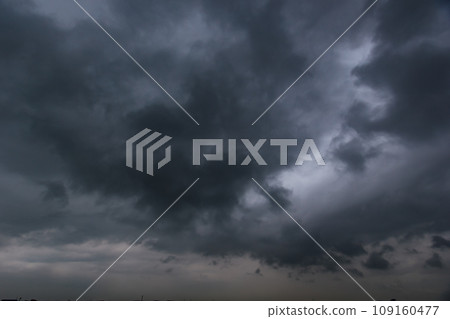 The dark sky with heavy clouds converging and a violent storm before the rain.Bad or moody weather sky and environment. carbon dioxide emissions, greenhouse effect, global warming, climate change. 109160477