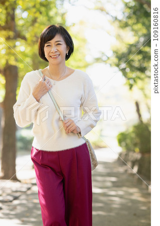 A woman in her 50s walking in the park A woman in her 50s walking in the park 109160816