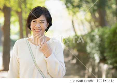 A woman in her 50s walking in the park A woman in her 50s walking in the park 109160818