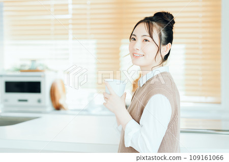 一個年輕的女人在客廳裡放鬆。 一個年輕的女人在客廳裡放鬆。 109161066