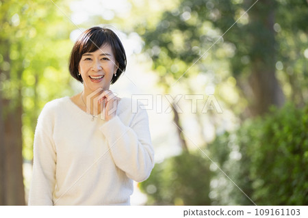 A woman in her 50s walking in the park 109161103