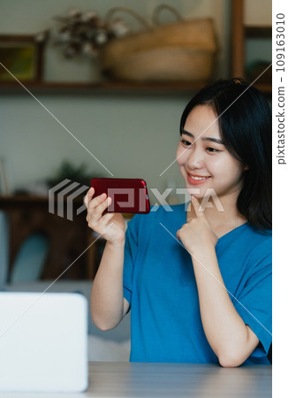 在智慧型手機上觀看影片的年輕女子 109163010