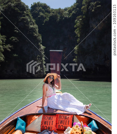 Traveler woman in summer dress relaxing on wooden boat joy view of Phang Nga bay, near Phuket, Travel in nature place Thailand, Traveler woman in summer dress relaxing on wooden boat joy view of Phang Nga bay, near Phuket, Travel in nature place Thailand, 109163115