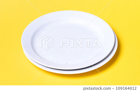 Two white plates on a solid background Two white plates on a solid background 109164012