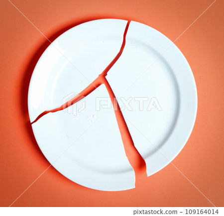 Broken white plate on a solid background Broken white plate on a solid background 109164014