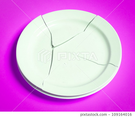 Broken white plate on a solid background Broken white plate on a solid background 109164016