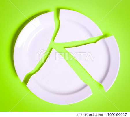 Broken white plate on a solid background Broken white plate on a solid background 109164017