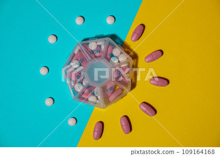Organizer weekly shots medical pill box with doses of tablets for daily take medicine with white pink drugs and capsules. Copy space Daily vitamins at home. Health care and diseases cure Organizer weekly shots medical pill box with doses of tablets for daily take medicine with white pink drugs and capsules. Copy space Daily vitamins at home. Health care and diseases cure 109164168