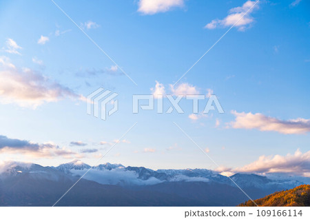 Snow-capped Northern Alps and mountains with autumn leaves 109166114